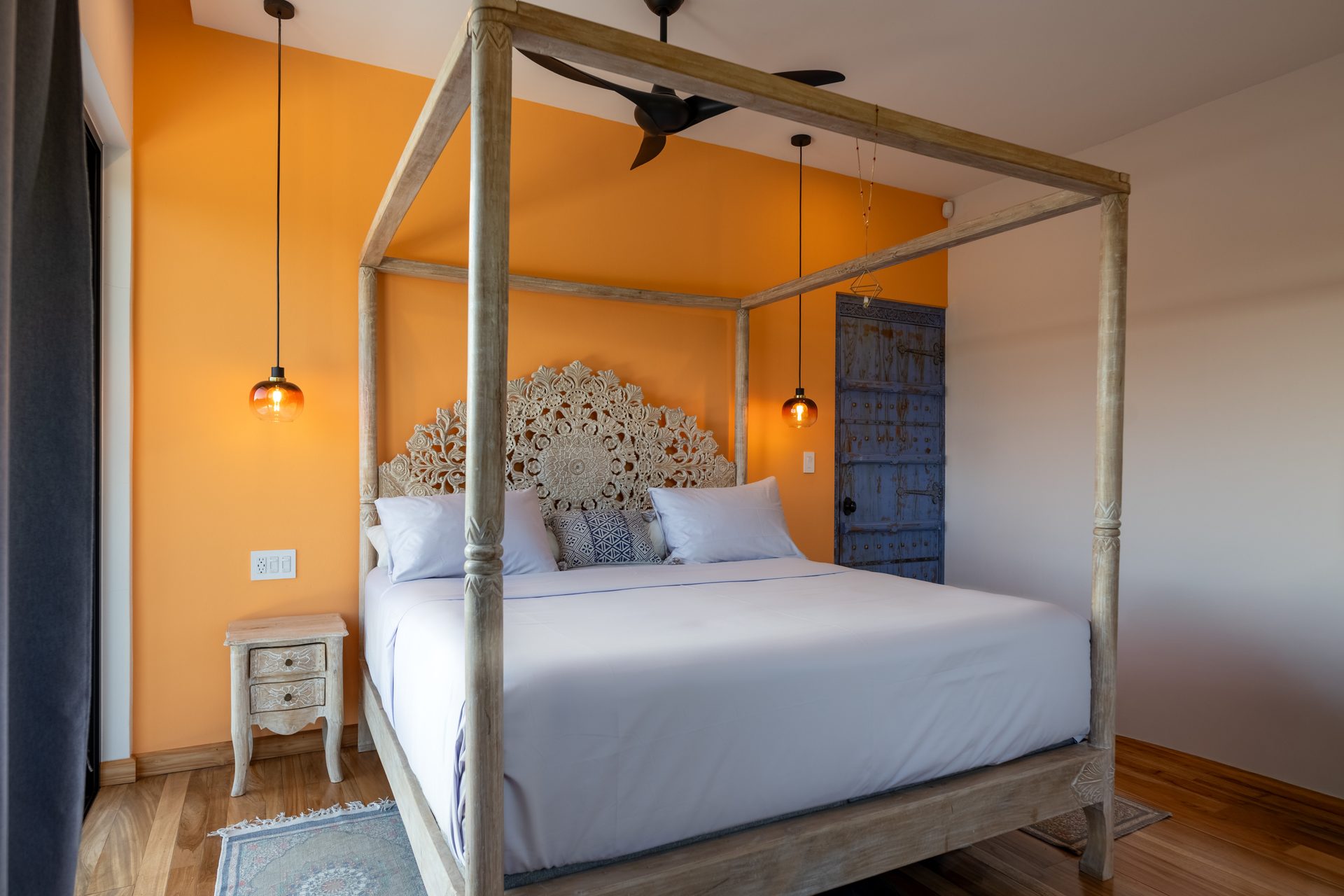 Orange bedroom and antique door — The Sanctuary Estate, Nosara, Costa Rica
